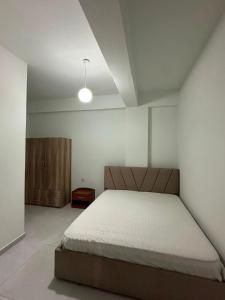 a bedroom with a bed and a wooden cabinet at Ikon Apartments in Kashari