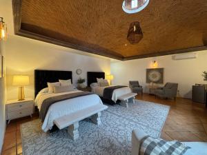 a bedroom with two beds and a living room at Tres Fuentes Dickinson Hotel Boutique in San Miguel de Allende +112 photos