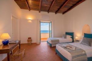 a bedroom with two beds and a desk and a window at Villa Belvedere Amodeo - terrace, seaview, wifi in Conca dei Marini