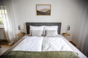 a bedroom with a large bed with white sheets and pillows at Franz 38 - Appartement Hallstatt in Hallstatt