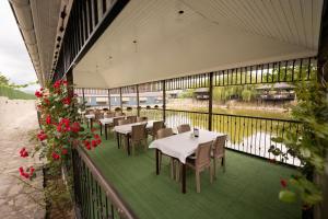 a restaurant with tables and chairs on a balcony at Forelle Restaurant & Motel in Çuxuryurd