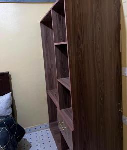 a wooden bookcase with drawers in a bedroom at Petalluxe k24 in Narok