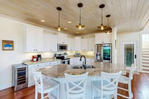 a kitchen with a large island with white cabinets at Sweet Carolina in Edisto Island