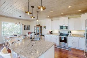 a kitchen with white cabinets and a large counter top at Sweet Carolina in Edisto Island +16 photos