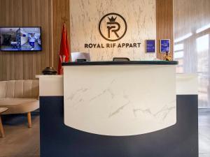 a lobby with a reception counter with a royal hr agent sign at Royal Rif Alhoceima in Al Hoceïma