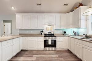 a kitchen with white cabinets and a stove top oven at Pompano End in Edisto Island