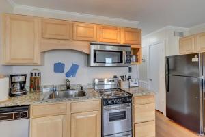a kitchen with wooden cabinets and a stainless steel refrigerator at HH Beach & Tennis 344B in Hilton Head Island