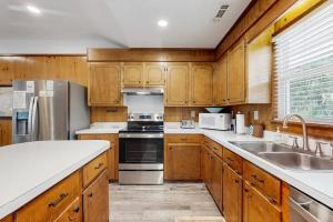 a kitchen with wooden cabinets and stainless steel appliances at Feeling Tip'Sea in Edisto Island +14 photos