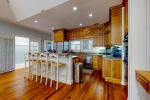 a kitchen with wooden cabinets and a bar with stools at Natural Wonder in Edisto Island +31 photos