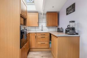 a small kitchen with wooden cabinets and a sink at Countryside Studio with Private Sauna in Sacomb