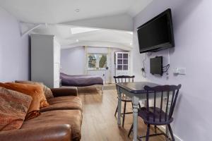 a living room with a couch and a table at Countryside Studio with Private Sauna in Sacomb