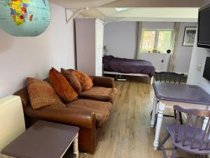 a living room with a couch and a table at Countryside Studio with Private Sauna in Sacomb +5 photos