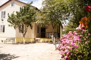 a house with trees and flowers in front of it at Forelle Restaurant & Motel in Çuxuryurd