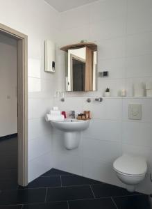 a white bathroom with a sink and a toilet at Hannover Central Apartment in Hannover