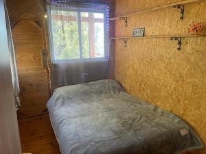a small bed in a room with a window at Shepherds Cabin in Kadita - בקתת רועה בקדיתא in Kadita