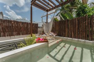 a swimming pool with a hammock on a fence at Casa Aura Hotel, Mérida in Mérida