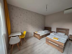 ein Zimmer mit zwei Betten, einem Tisch und einem Schreibtisch in der Unterkunft Bee House in Kilda