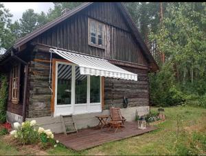 a log cabin with a porch and a table and chairs at Good Chata Leśna Polana in Dobry Las
