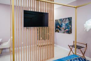 a living room with a partition with a television on it at Le Pepite Collection in Giardini Naxos