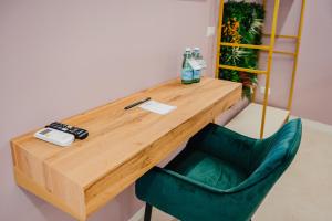 a wooden desk with a green chair and a bottle of water at Le Pepite Collection in Giardini Naxos