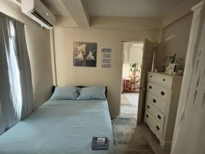 a small bedroom with a blue bed and a dresser at T & H Oasis in Kingstown