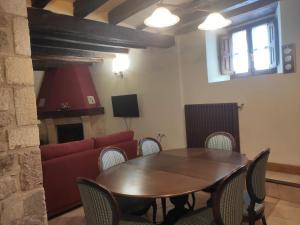 a living room with a table and a red couch at Etxezarra in Sáseta +8 photos