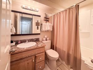 a bathroom with a toilet and a sink and a shower at The Beach House I in Garden City +39 photos