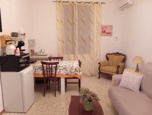 a living room with a couch and a table and chairs at Elico Di Sicilia home B in Sambuca di Sicilia