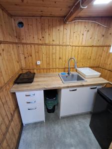 a kitchen with a sink in a wooden wall at Namiot glampingowy u Kasi in Pojezierze