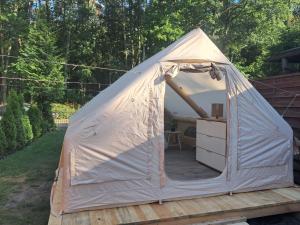 a white tent sitting on a wooden deck at Namiot glampingowy u Kasi in Pojezierze