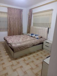 a bedroom with a bed and a wooden floor at بيت مفروش للايجار-عجلون-اشتفينا in Ajloun