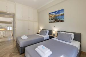 a bedroom with two beds with towels on them at Syros Private House with superb sea view in Kini