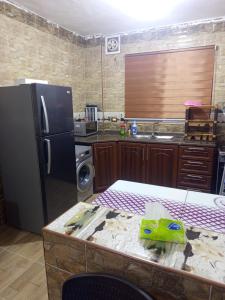 a kitchen with a black refrigerator and a counter top at بيت مفروش للايجار-عجلون-اشتفينا in Ajloun