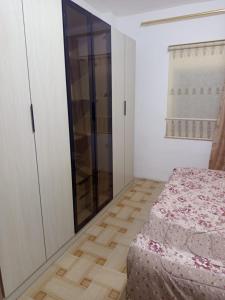 a bedroom with a bed and a glass cabinet at بيت مفروش للايجار-عجلون-اشتفينا in Ajloun