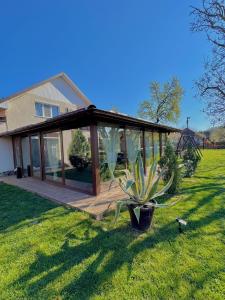 a house with a wooden deck with a glass house at Denisa & Rares in Tăşnad