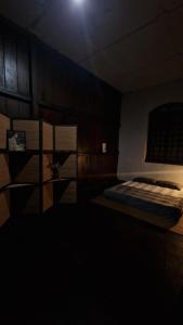 a bedroom with a bed in a dark room at Thai Traditional Home in Bangkok