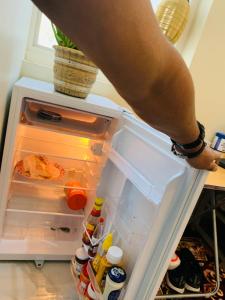 a person is reaching into an open refrigerator at Rooms & Suites Western Dhafra Housing in Ghayathi +5 photos