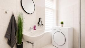 a white bathroom with a sink and a mirror at Beesenkammer - zentrales StudioApartment Halle in Halle an der Saale