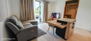 a living room with a chair and a table at RM Westside Apartment in Case Noyale
