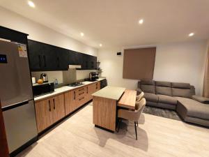 a kitchen and living room with a table and a couch at RM Westside Apartment in Case Noyale