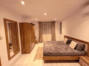 a bedroom with a bed and a dresser at RM Westside Apartment in Case Noyale