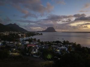 a view of a town and the water with a mountain at RM Westside Apartment in Case Noyale