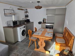 a kitchen with a table and a kitchen with a microwave at Le Repos du Jorat in Saint-Maurice