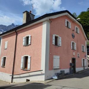a large red brick building with a clock on it at Le Repos du Jorat in Saint-Maurice