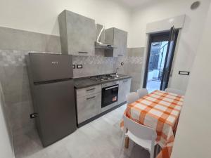 a kitchen with a table and a stainless steel refrigerator at pomelia holiday house in Riposto