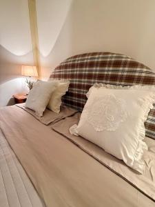 a bed with two white pillows on top of it at Maison Moena Dolomites in Moena