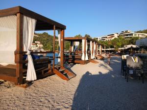 a row of umbrellas and chairs on a beach at Relax tiny villas 40 meters of the beach in Korčula
