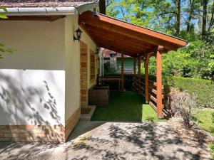 a porch of a house with a wooden pergola at Tommy's Cottage in Harta