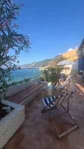 a patio with a table and chairs and the ocean at Casa delle Galee in Scilla
