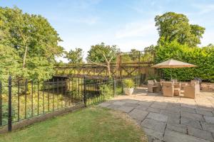 a wrought iron fence with chairs and an umbrella at 5 Bed in Belper oc-b29775 in Belper